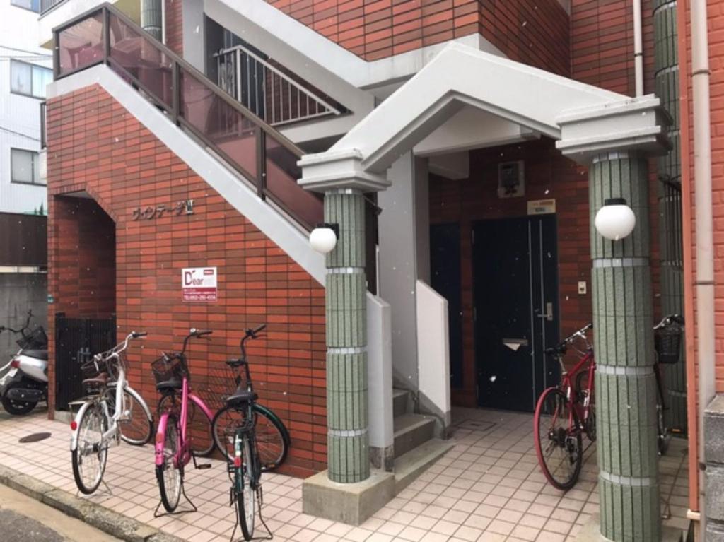 three bikes parked in front of a building at Vintage III - Vacation STAY 14774 in Fukuoka