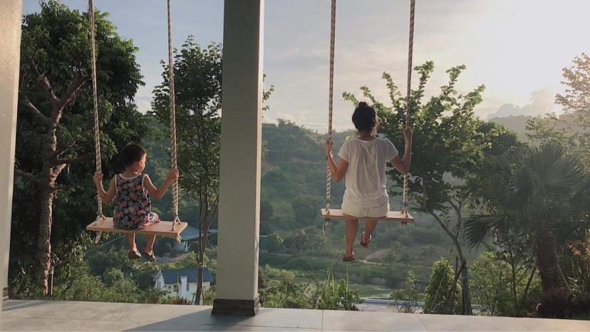 twee meiden swingend op een schommel in een huis bij BlueHome Villa in Hòa Bình