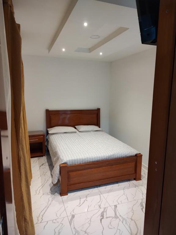 Hotel RA04 في Chachagüí: غرفة نوم بسرير في غرفة بيضاء
