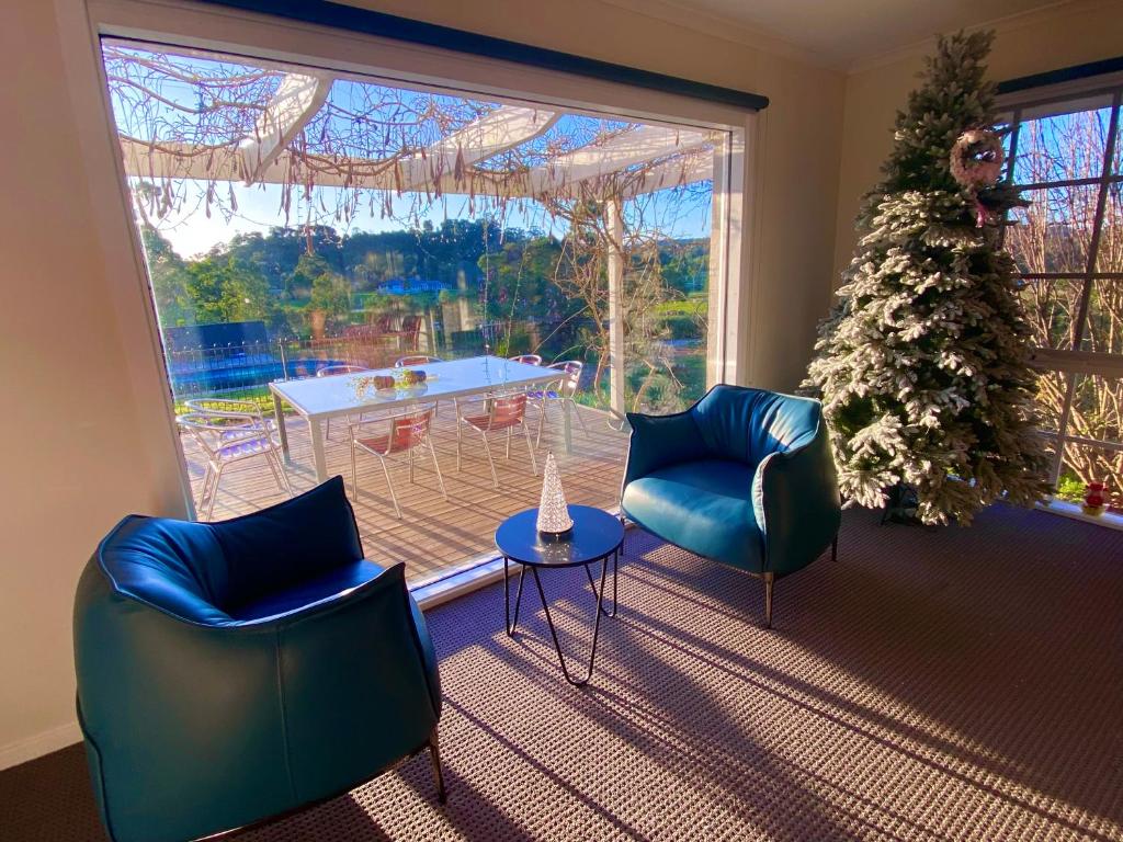 Wonga Park的住宿－Heritage Holiday House No.17，客厅配有两把椅子和一棵圣诞树