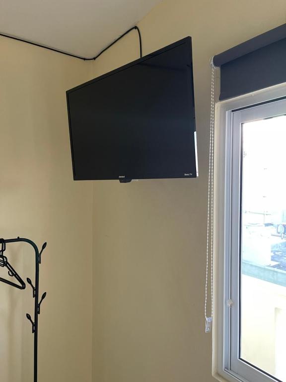 einen Flachbild-TV, der an einer Wand neben einem Fenster hängt in der Unterkunft Isla Bonita - Isla Mujeres centro in Isla Mujeres