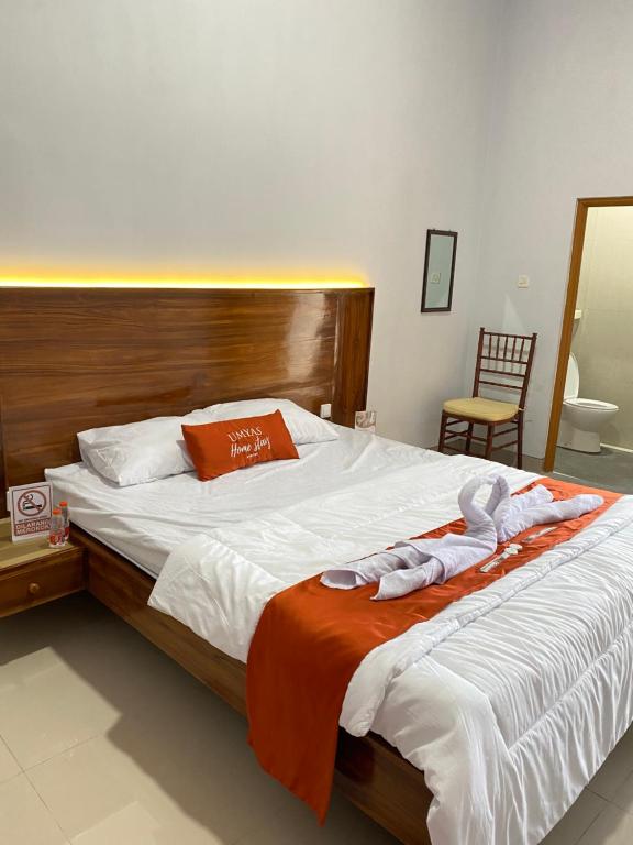Umyas Hotel Syariah في Nganjuk: غرفة نوم بسرير كبير عليها مناشف