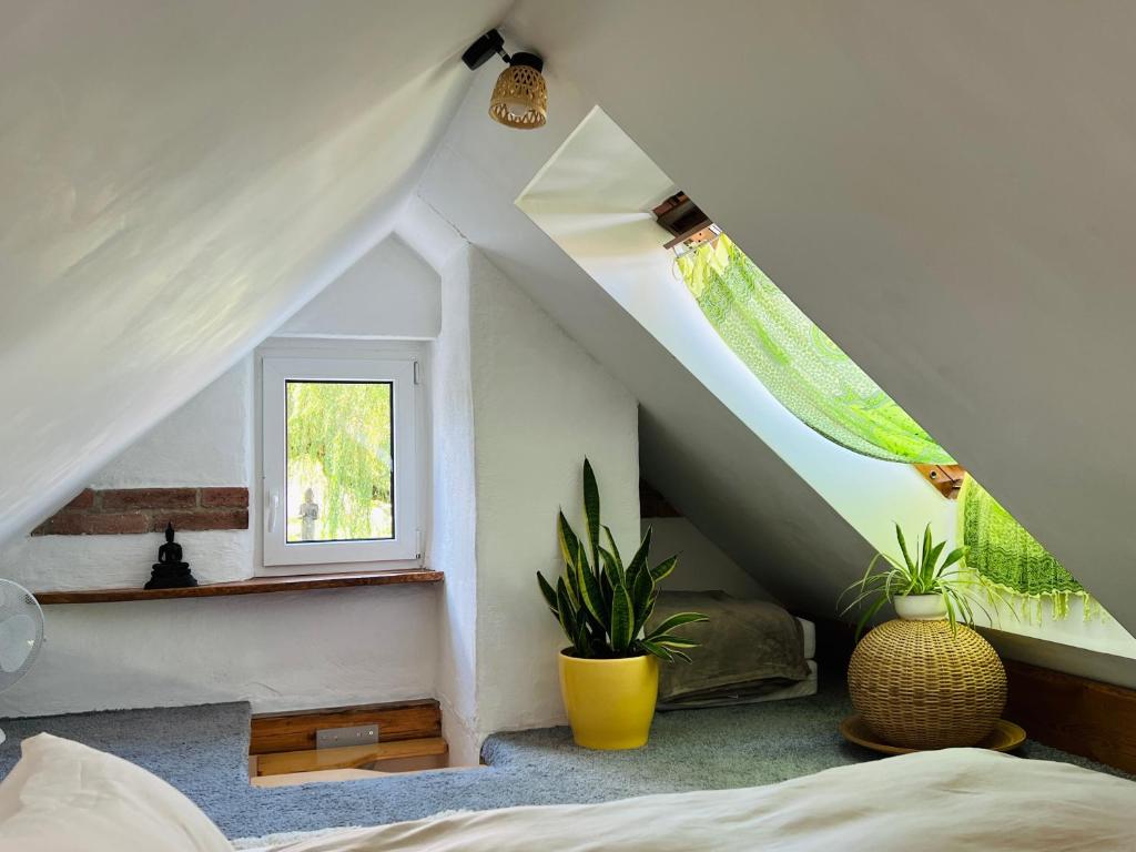 um quarto no sótão com uma cama e uma janela em Bali-Style Tinyhaus am Wald em Bruckberg