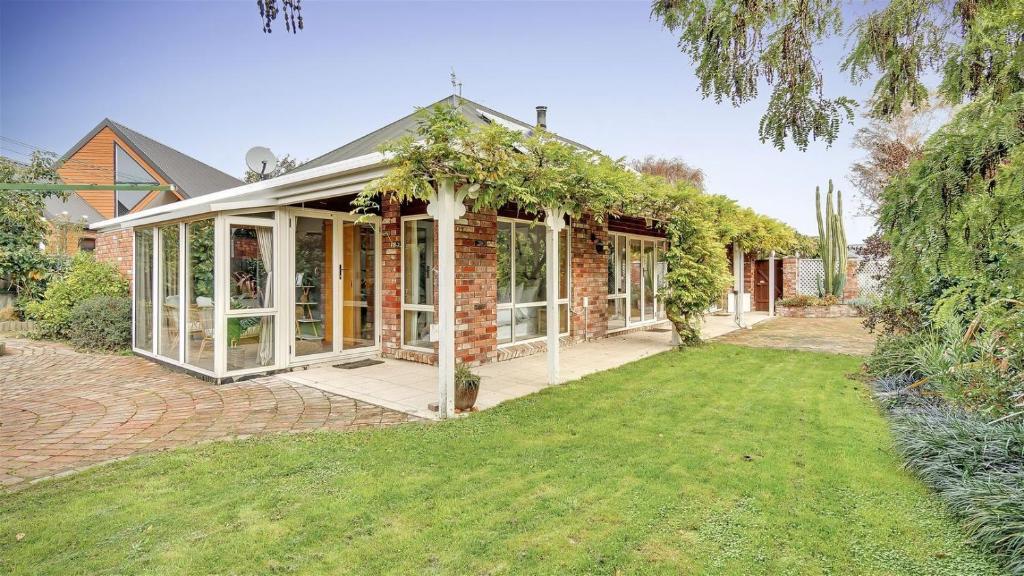 una casa de ladrillo con un salón acristalado con vides en Sweet Home, en Christchurch