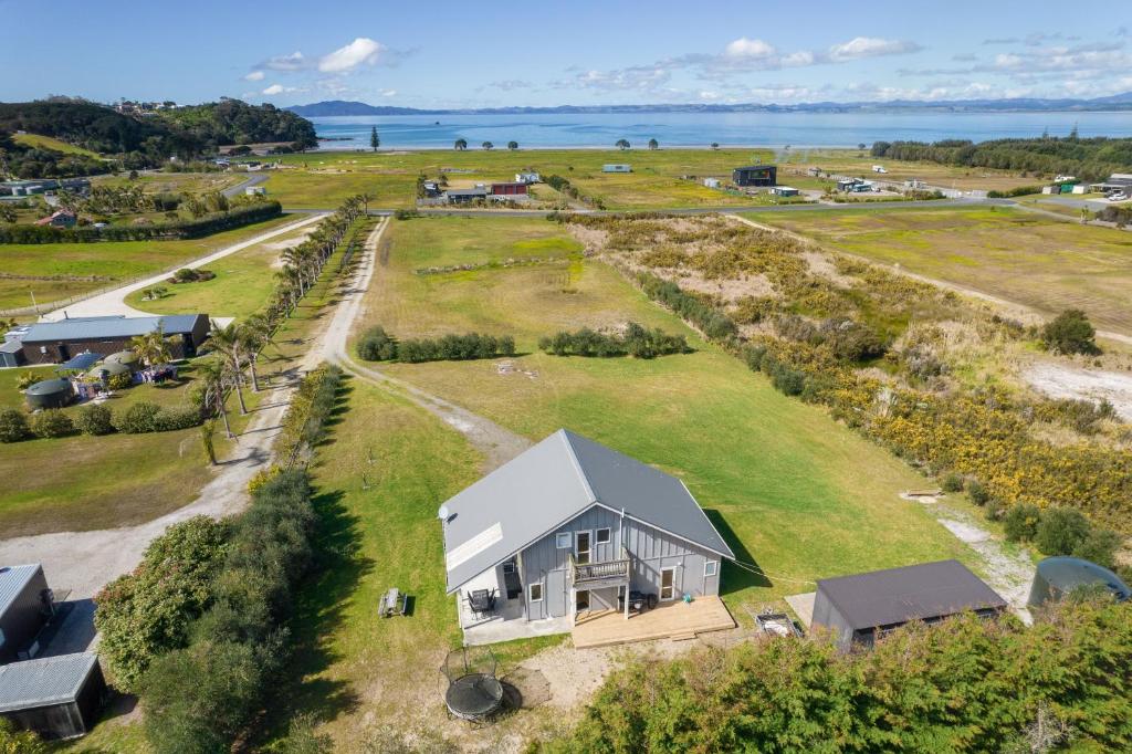 an aerial view of a small house on a grass field at Tokerau Magic - Karikari Peninsula Holiday Home in Kaitaia