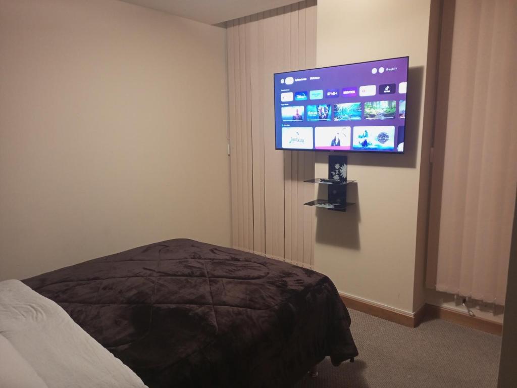 a bedroom with a flat screen tv on the wall at Apartamento en La Paz in La Paz