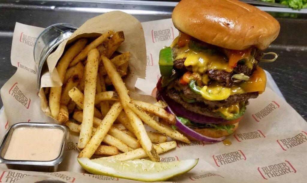 a cheeseburger and french fries with a pickle at Holiday Inn & Suites Durango Downtown by IHG in Durango