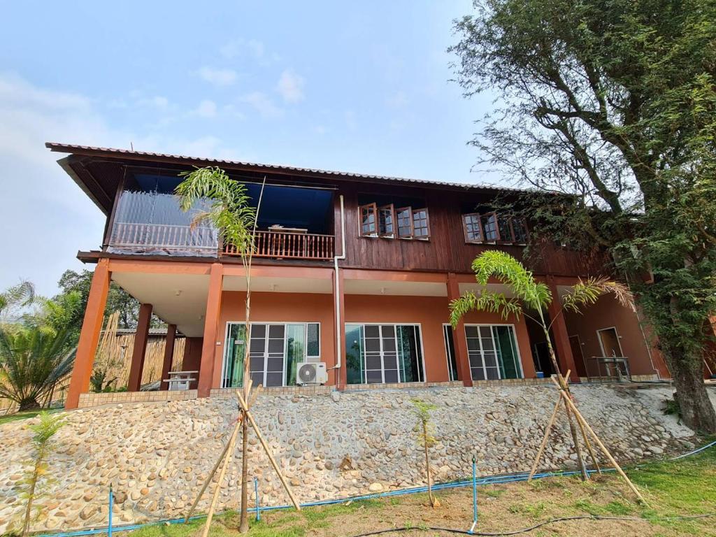 a house on top of a stone wall at Khunkhao Maenamchan Homestay ขุนเขา แม่น้ำจัน โฮมสเตย์ in Chiang Rai