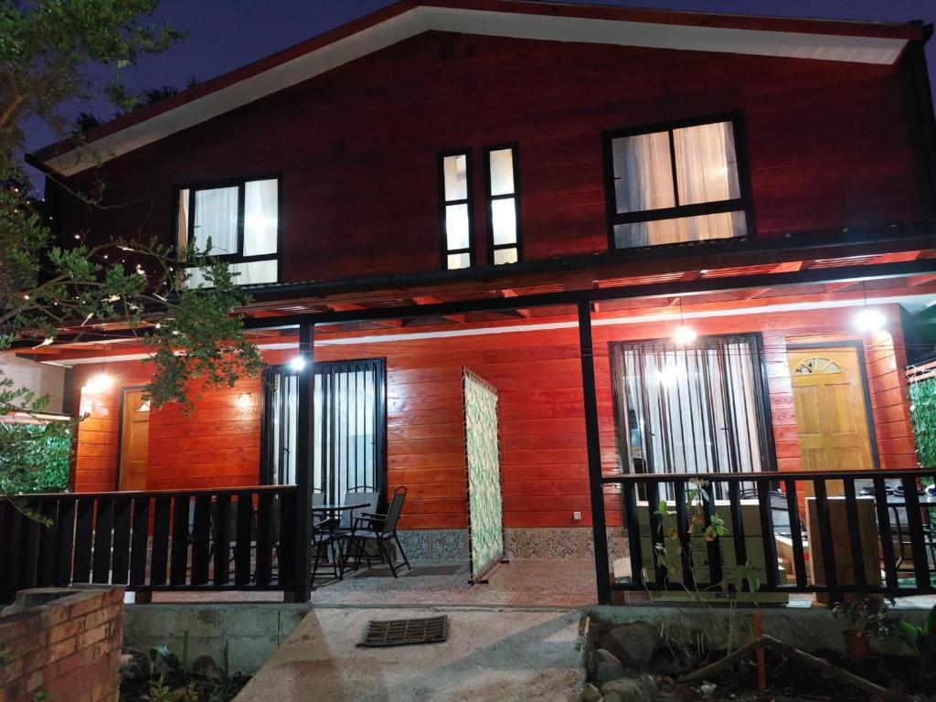 uma casa de madeira com um alpendre à noite em CABAÑAS 88 Y 8 em Coñaripe