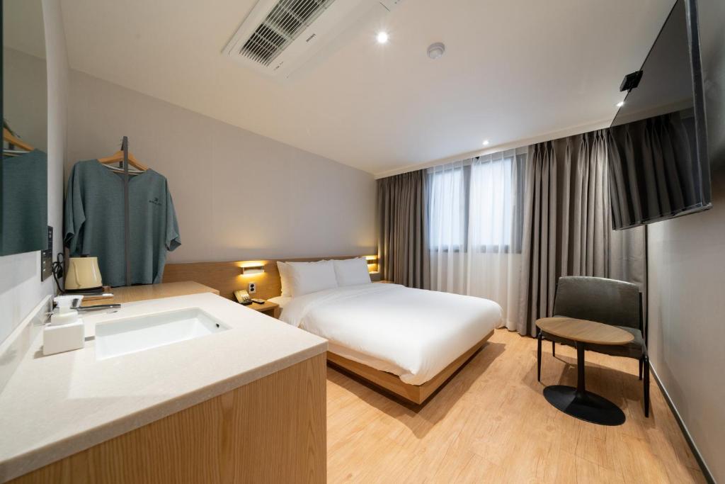 Pokój hotelowy z łóżkiem i umywalką w obiekcie Hotel 23 w mieście Ulsan