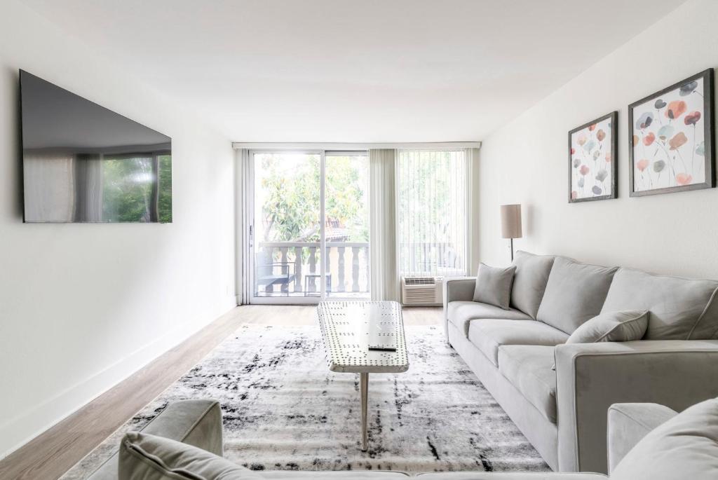 a white living room with a couch and a table at New Luxury Apartment WeHo Boys Town in Los Angeles