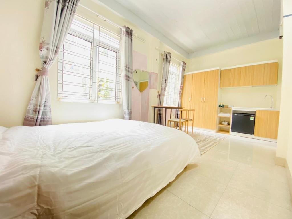 une chambre avec un grand lit blanc et une cuisine dans l'établissement Easystay Apartment - 9B Phố An Hòa, quận Hà Đông, Hà Nội, à Hanoï