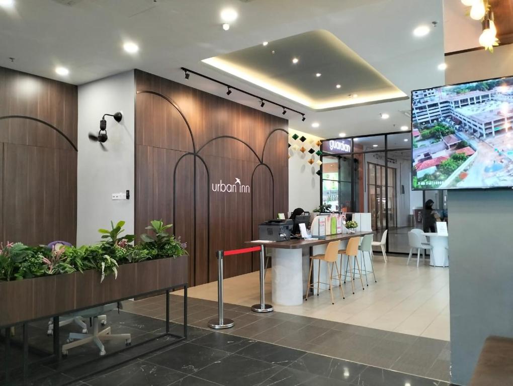 a lobby of a office with a counter and chairs at Urban Inn, Alor Setar in Alor Setar