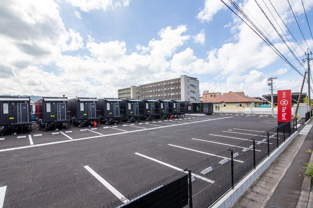 a parking lot with a row of train cars at HOTEL R9 The Yard Kirishimakokubu in Kirishima