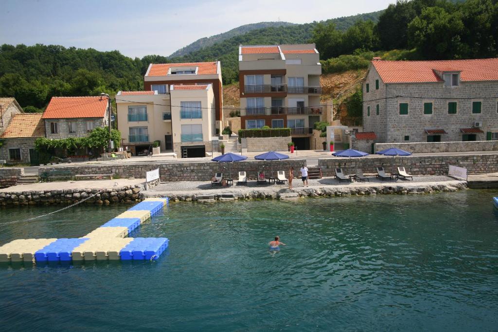 une personne dans l'eau d'une piscine dans l'établissement Apartments Villa Jelena, à Tivat