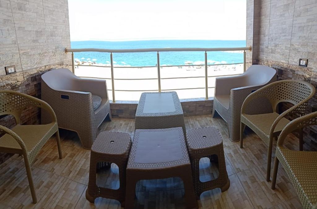 Paradise Beach Alexandria Sea View - Free Wi-Fi - Alex في الإسكندرية: طاولة وكراسي في غرفة مطلة على الشاطئ