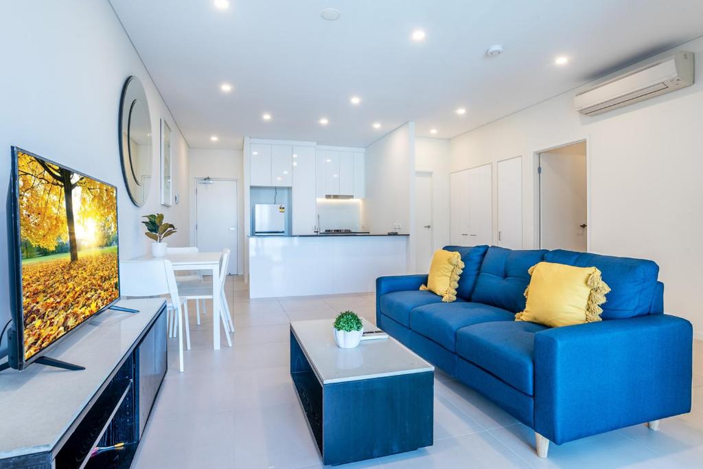 a living room with a blue couch and a kitchen at Comfort Two bedroom Apartment with Free parking In Valley in Brisbane