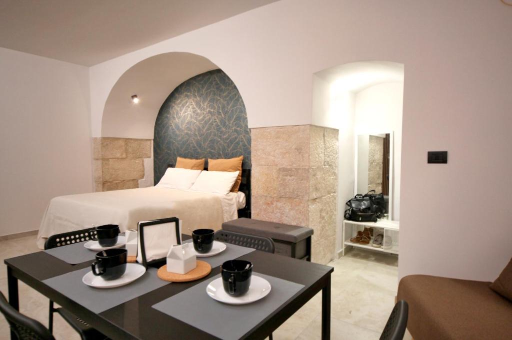 a hotel room with a bed and a table and chairs at Appartamento Maison De Ruelle in Barletta
