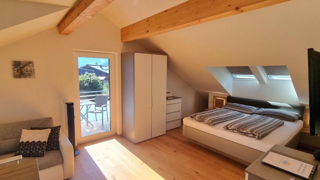 Schlafzimmer im Dachgeschoss mit einem Bett und einem Balkon in der Unterkunft The Apartment - Alpentherme inklusive in Bad Hofgastein