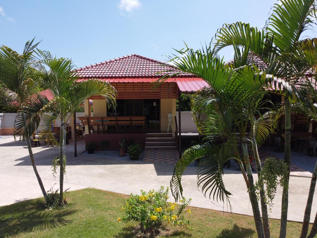 a house with palm trees in front of it at Naluemon Village FH 1 in Rayong