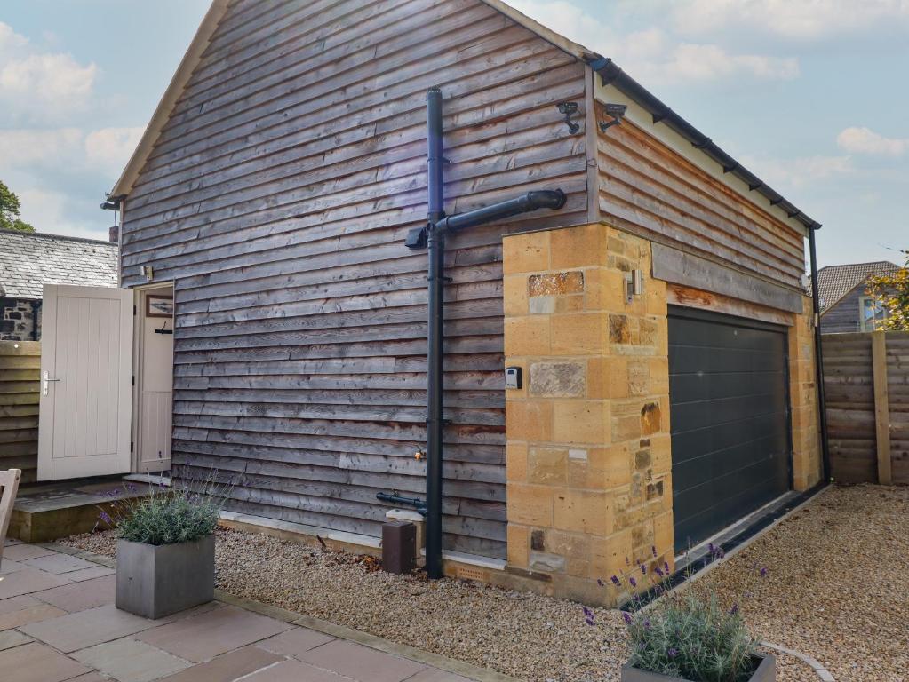 a building with a garage and a garage door at Bay Tree Studio in Alnmouth