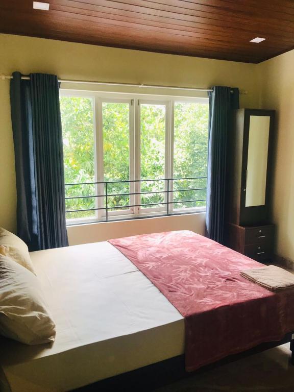 a bedroom with a large bed and a window at High shine Homestay in Meppādi