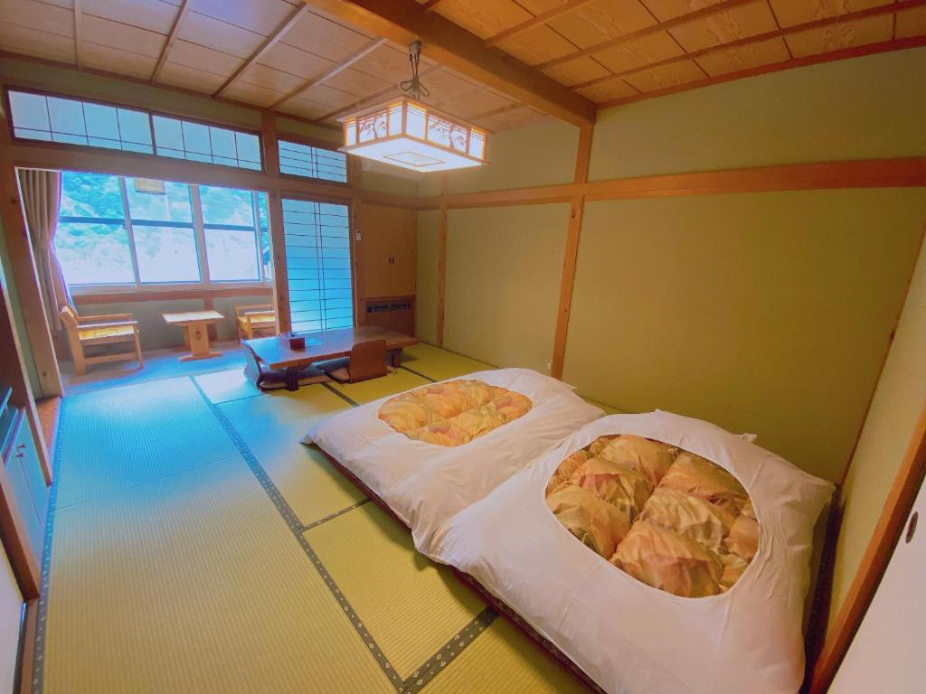 une chambre avec deux lits dans l'angle d'une pièce dans l'établissement Hakuunsou, à Takayama
