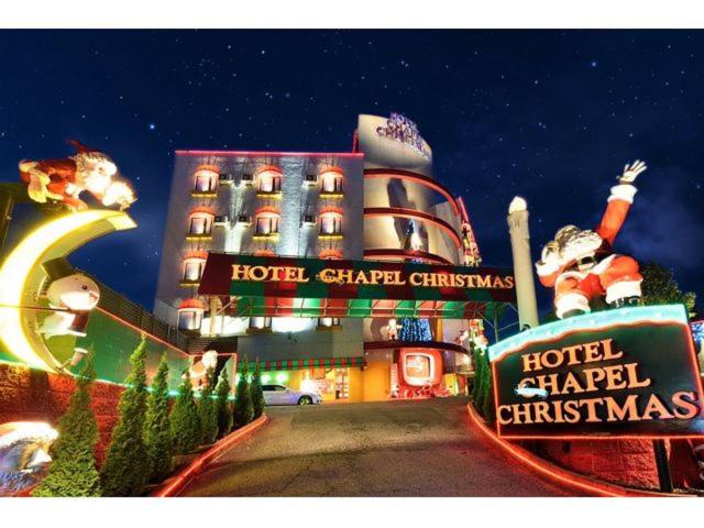 un hotel con carteles de Navidad delante de él en Hotel Chapel Christmas Narita -Adult Only en Narita