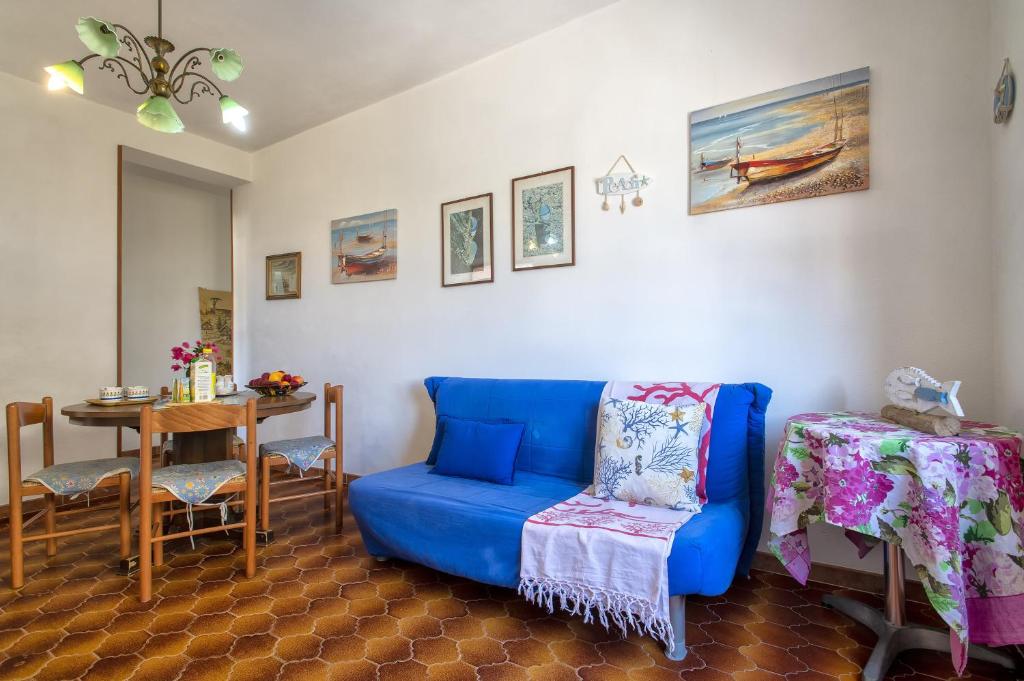 a living room with a blue couch and a table at Isola Rossa - Trilocale Grande in Isola Rossa