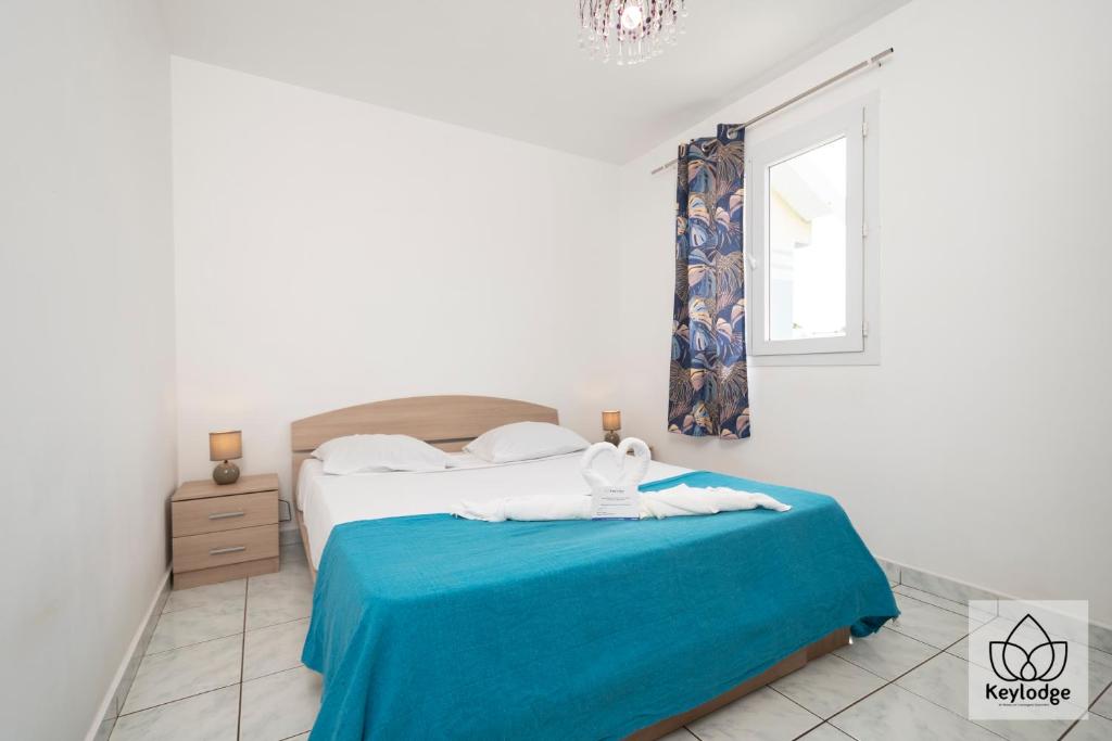 Bras-Panon的住宿－Gecko Zen - 3* - 95m2 - 20min du cirque de Salazie - Bras-Panon，一间卧室配有一张带蓝色毯子的床