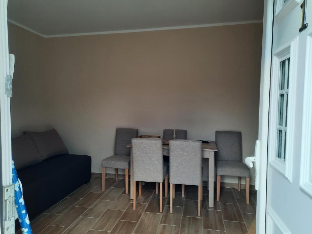 een eetkamer met een tafel en stoelen en een bank bij Mila in Bela Crkva