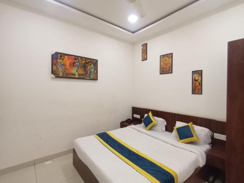 Postel nebo postele na pokoji v ubytování Hotel Lakshya Sheesh Mahal Indore