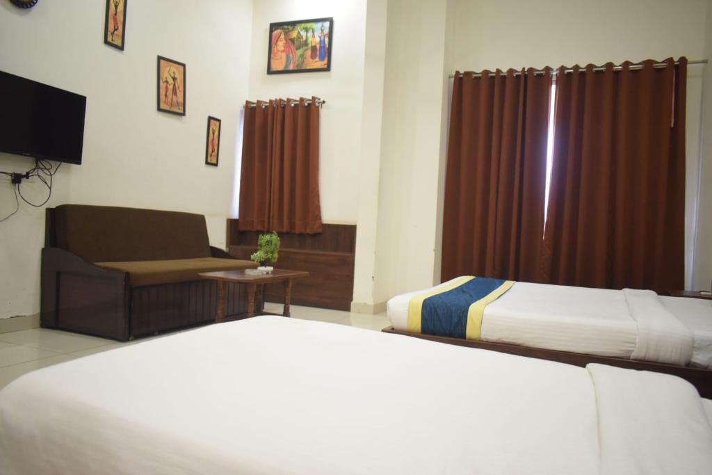 Postel nebo postele na pokoji v ubytování Hotel Lakshya Sheesh Mahal Indore