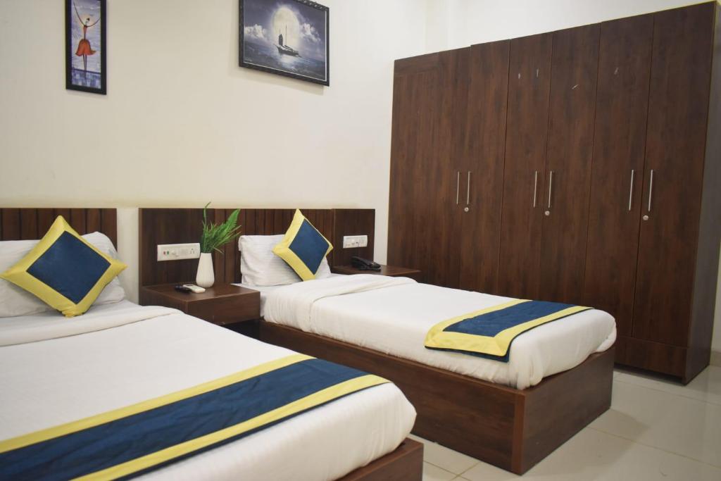 Postel nebo postele na pokoji v ubytování Hotel Lakshya Sheesh Mahal Indore