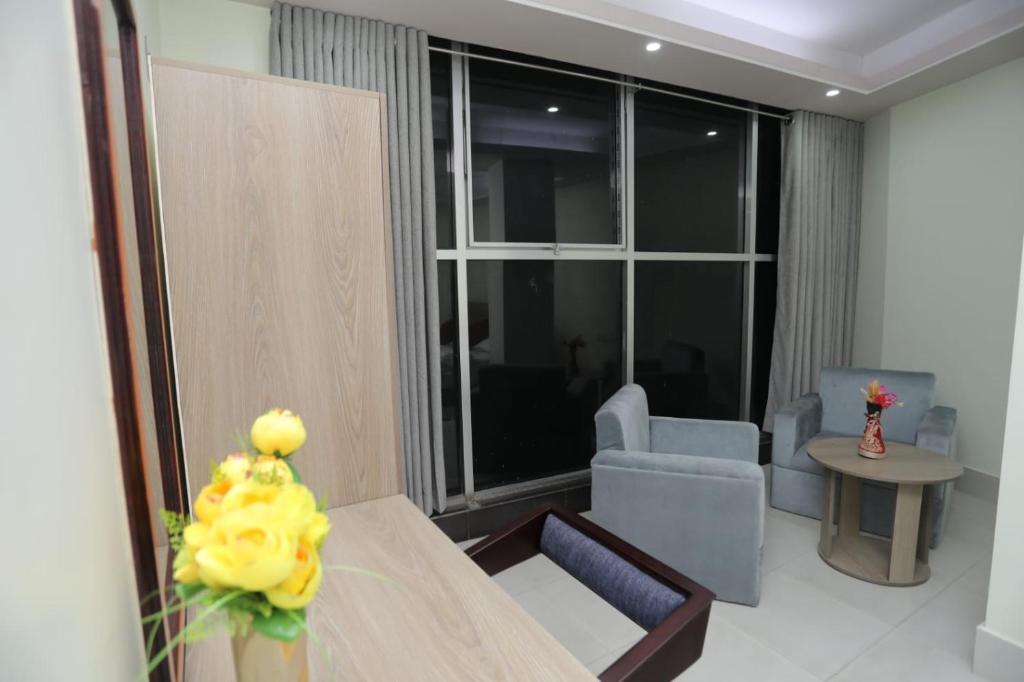 a room with a table and chairs and a large window at Wood Burn Hotel in Bogra
