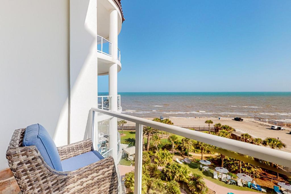 einen Balkon mit einem Stuhl und Blick auf den Strand in der Unterkunft Diamond Beach Resort Sunshine Sea Breezes in Galveston