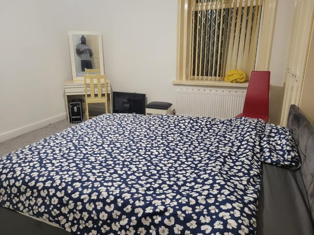 um quarto com uma cama, 2 cadeiras e uma janela em Room shared in 3bedroom house in Oldham Manchester em Moorside