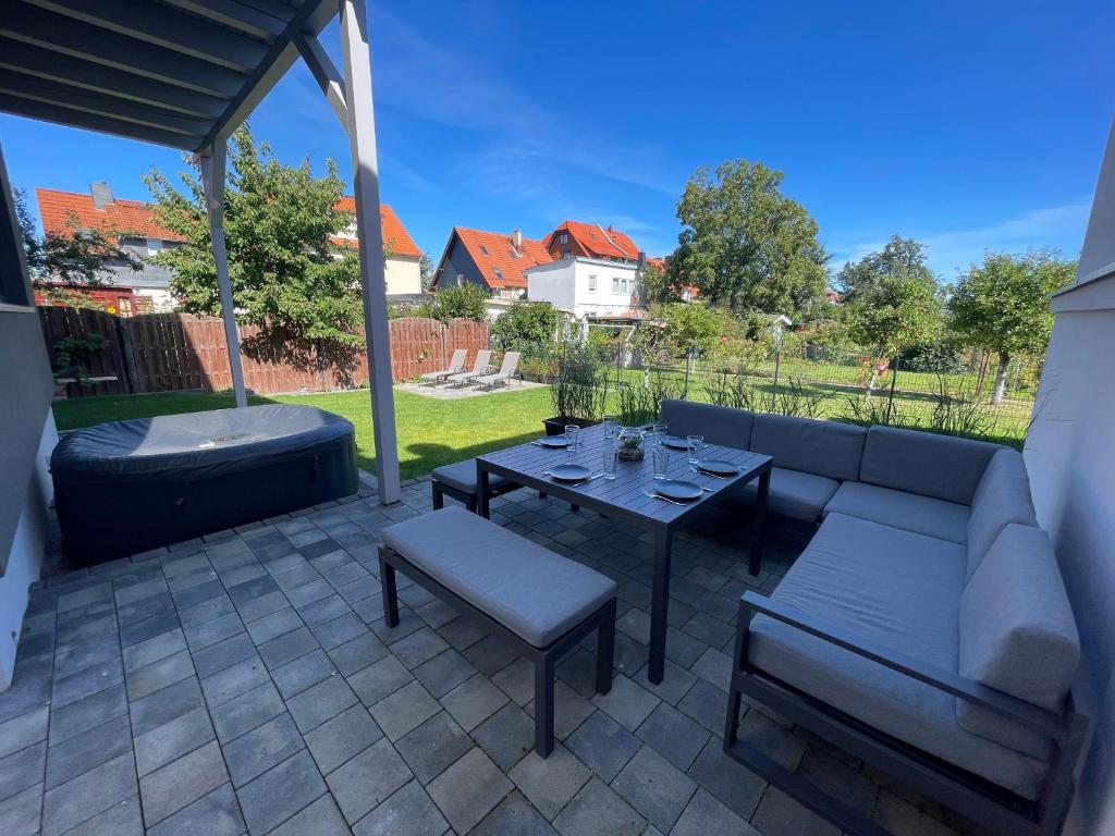 a patio with a couch and a table and chairs at Stilapartment Oasis 1 #Whirlpool saisonal in Wernigerode