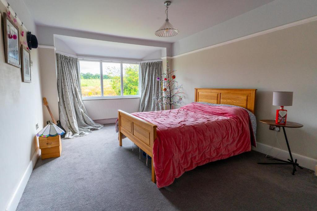a bedroom with a red bed and a window at Luxurious Private Accommodation Manchester Airport Stay Park And Fly Lyme Park in Hazel Grove
