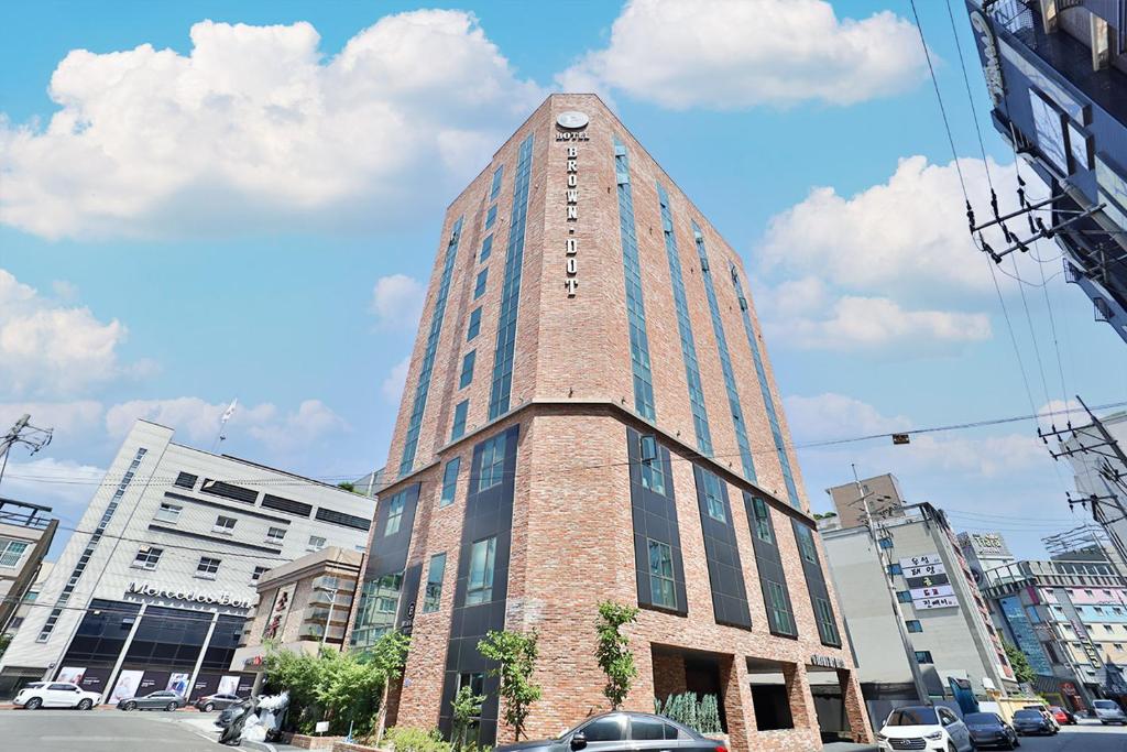 un edificio alto con un reloj encima en Brown Dot Hotel Ulsan Samsan en Ulsan