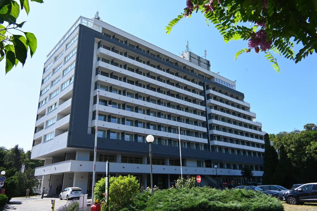 un gran edificio en un estacionamiento en Hotel Szieszta en Sopron