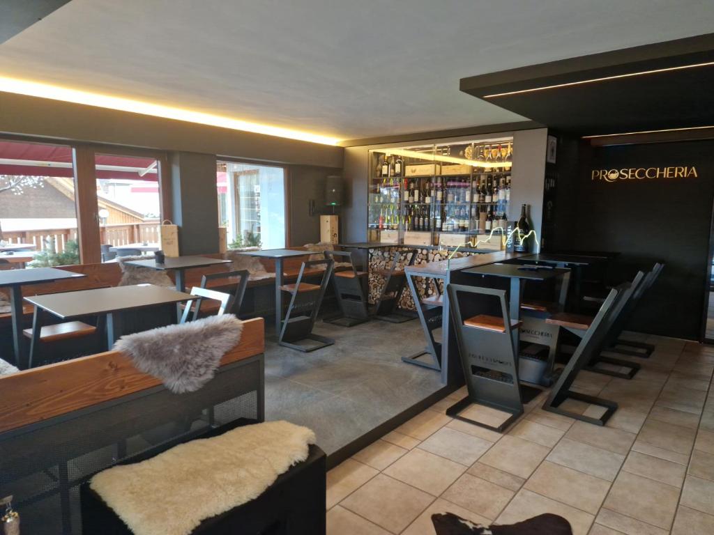 restauracja ze stołami i krzesłami oraz bar w obiekcie B&B La Montanara w mieście San Martino di Castrozza
