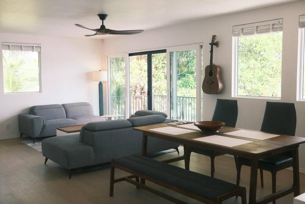 een woonkamer met een tafel en stoelen en een gitaar bij Aloha Beachfront ホノルル - Hawaii Kai in Honolulu