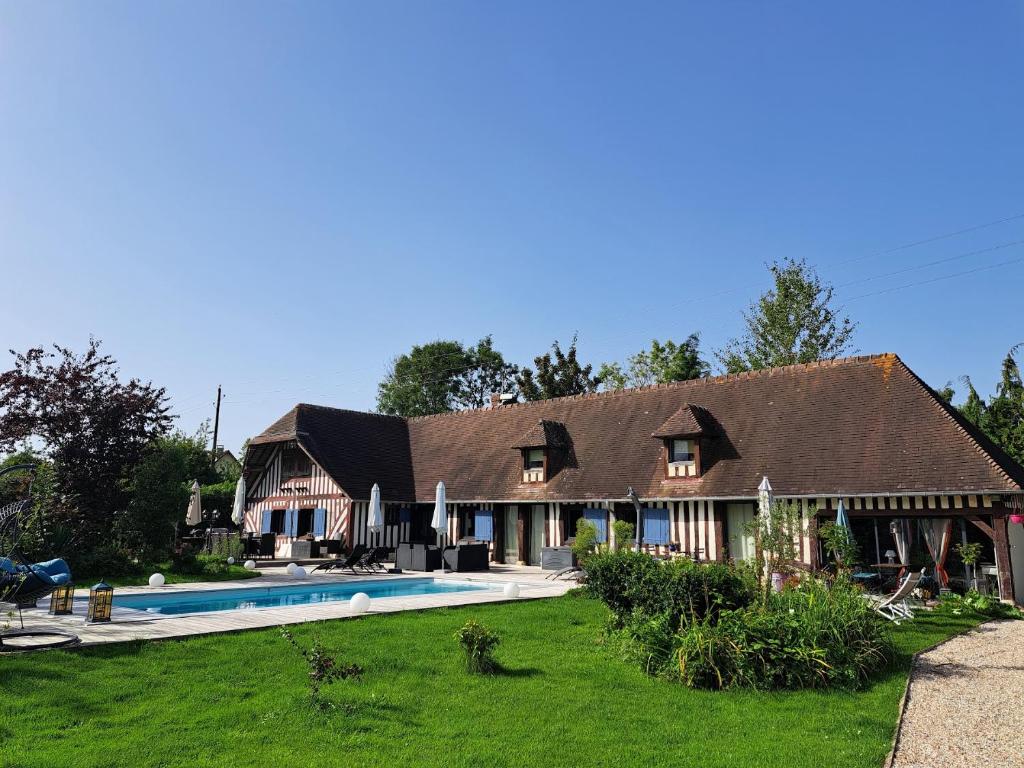 a large house with a swimming pool in the yard at Léalie in Gonneville-sur-Honfleur