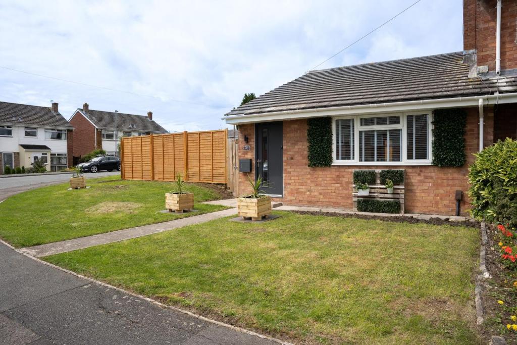 a house with a fence in the yard at Bungalow in Keynsham in Keynsham