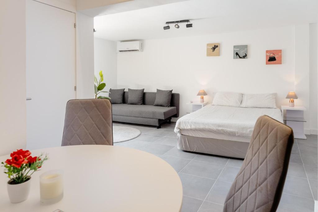 a bedroom with a bed and a table and a couch at Arrábida Guest Studio in Aldeia Rica