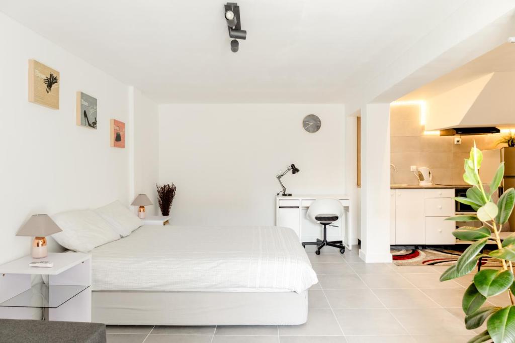 Habitación blanca con cama blanca y escritorio. en Arrábida Guest Studio, en Aldeia Rica
