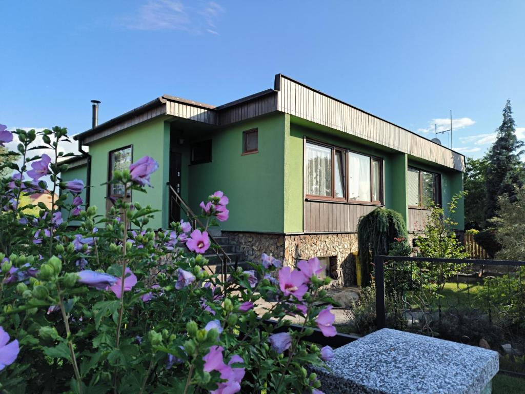 a green house with flowers in front of it at House of Relax in Řečany nad Labem