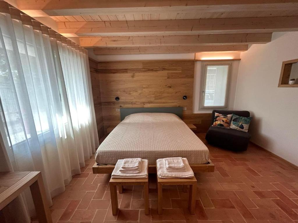 1 dormitorio con 1 cama y 1 silla en una habitación en Borgo Cortivi b&b, en Valdobbiadene