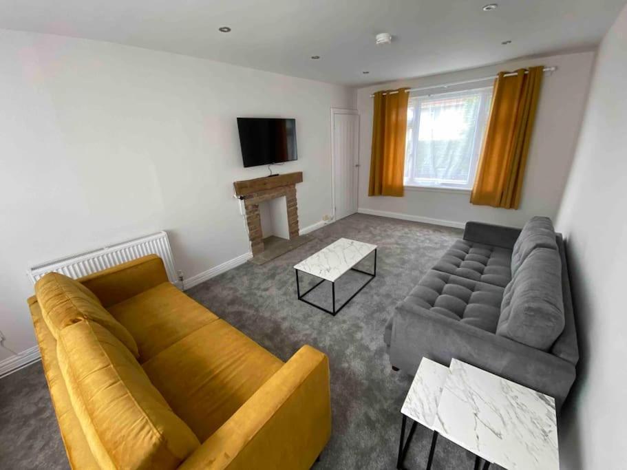 sala de estar con sofá y TV en Spacious Contemporary Home en Leeds